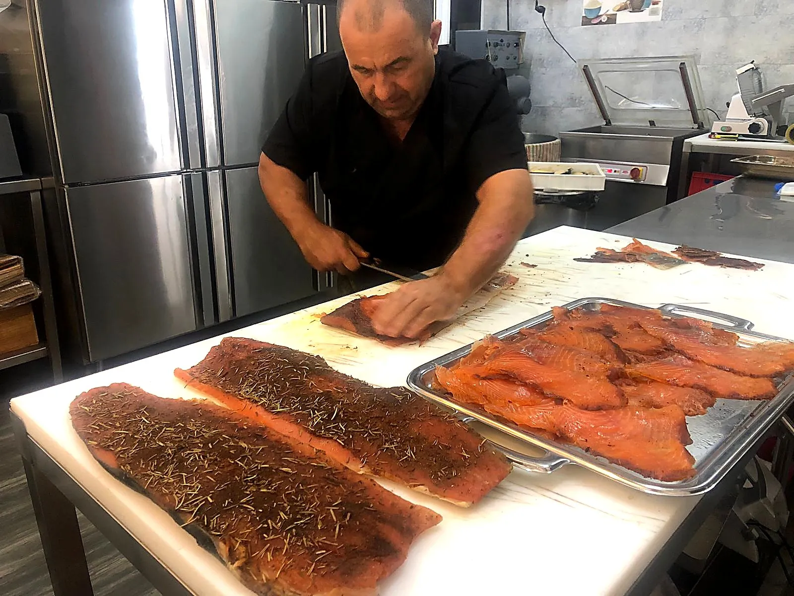 Le saumon fumé maison, tranché au couteau dans le labo